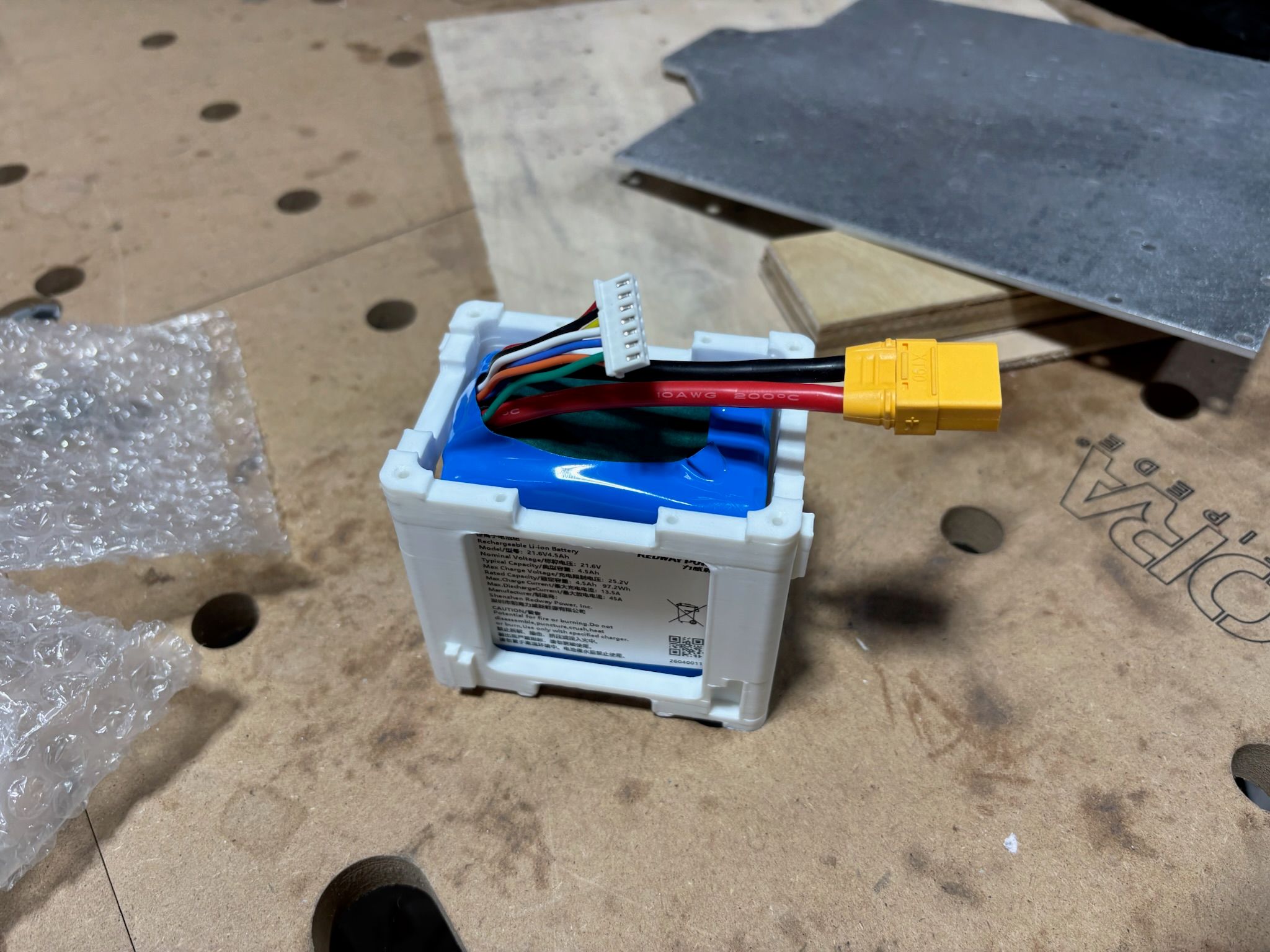 Student soldering the electronics harness for the first prototype on a workbench 2
