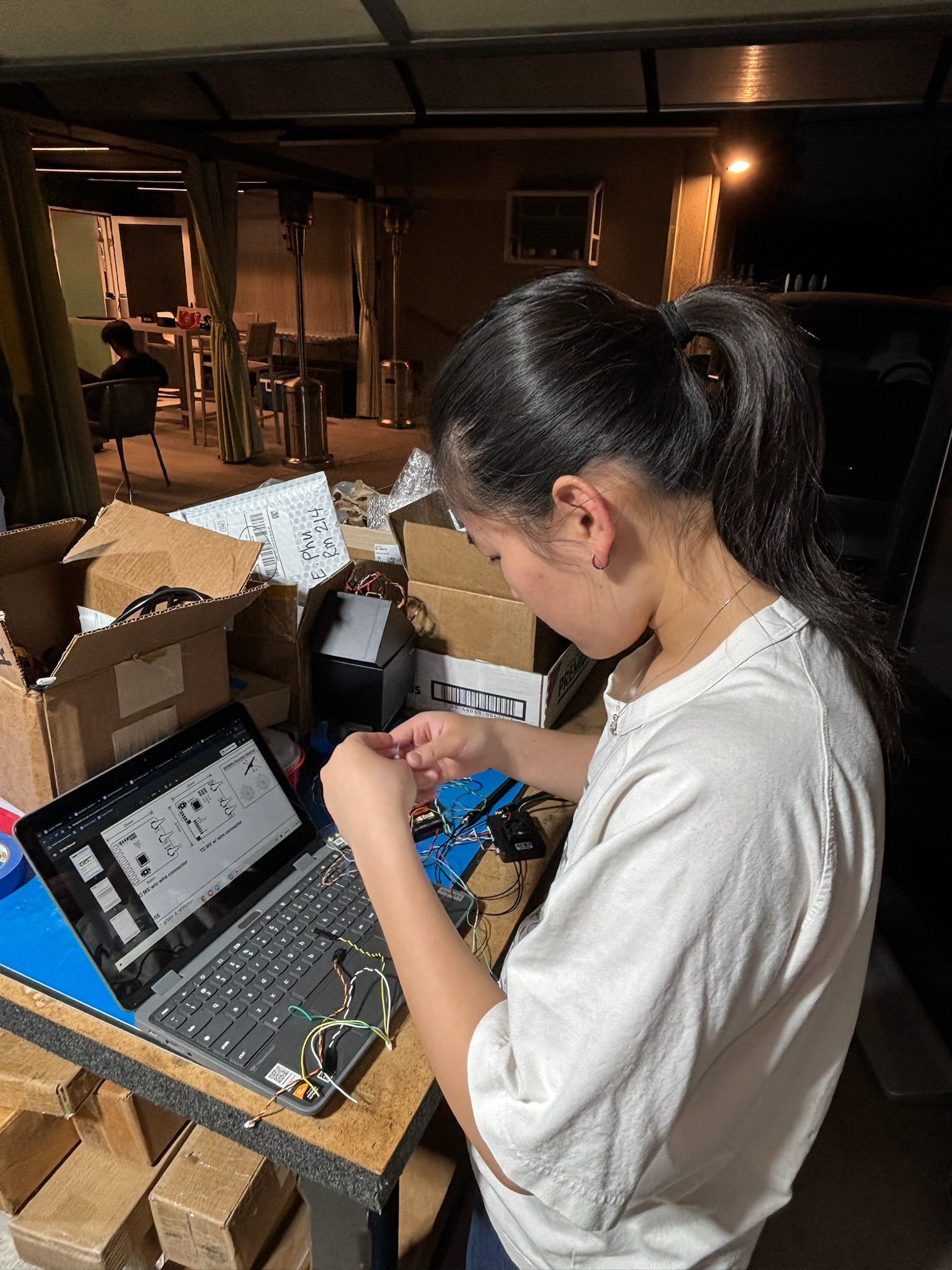 Student soldering the electronics harness for the first prototype on a workbench 4