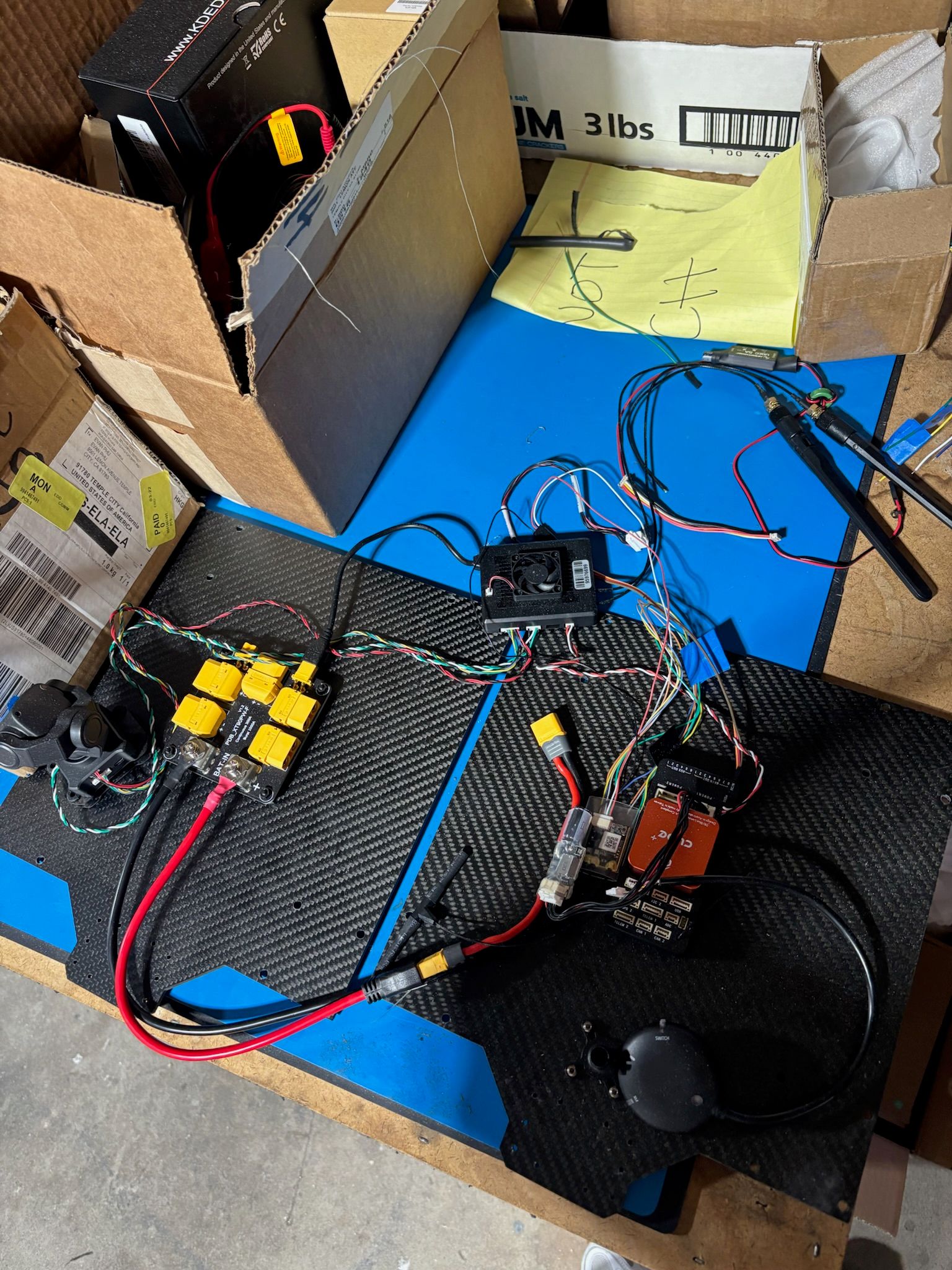 Student soldering the electronics harness for the first prototype on a workbench 6